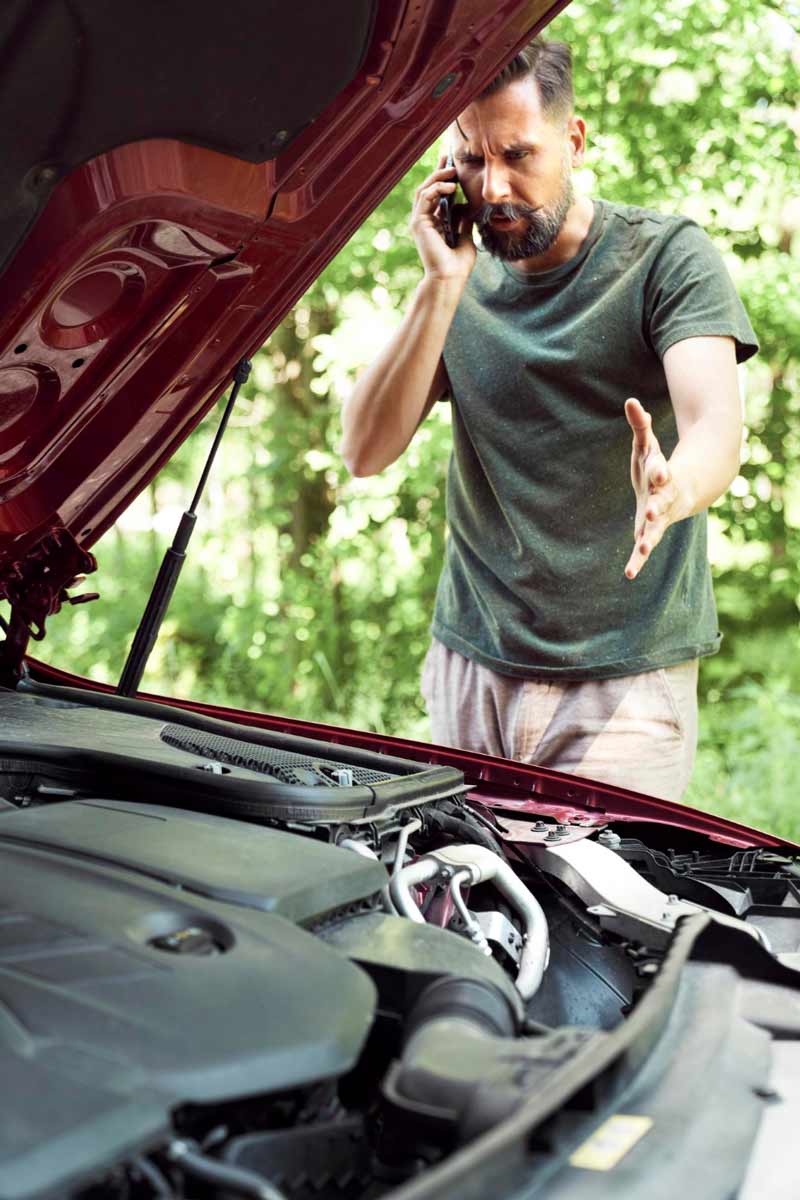 Junger Mann prüft Getriebeschaden bei Schrottauto Ankauf Herne